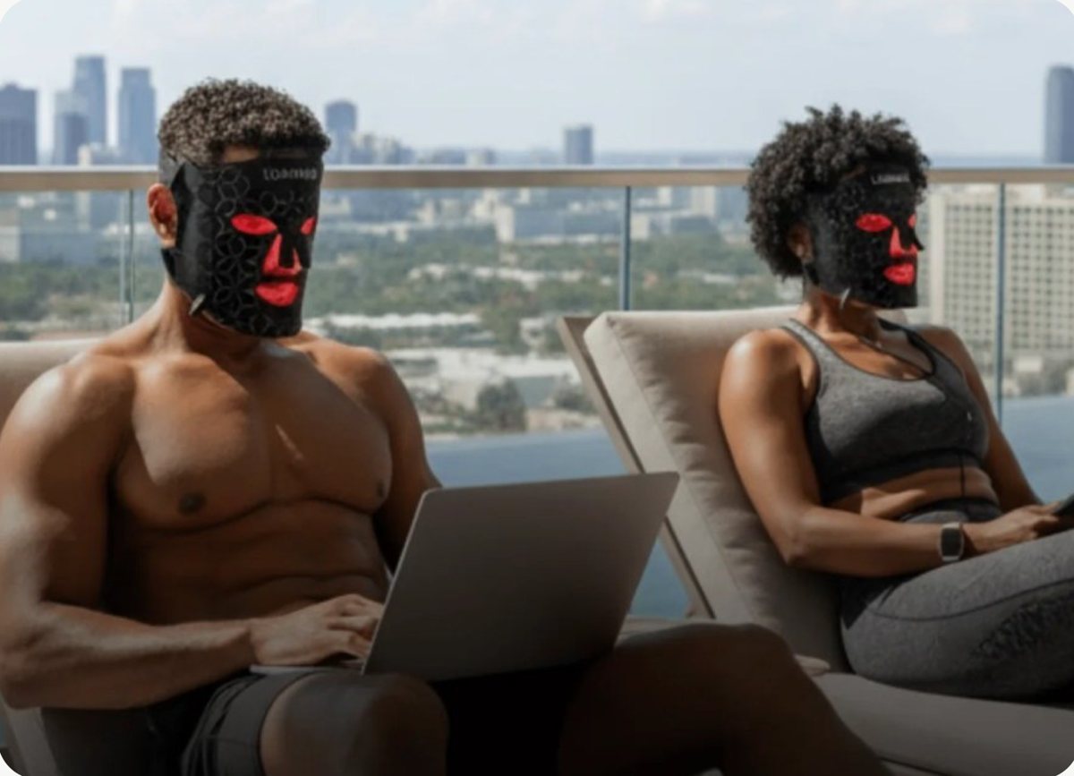 Two people wearing Lumara red-light therapy masks